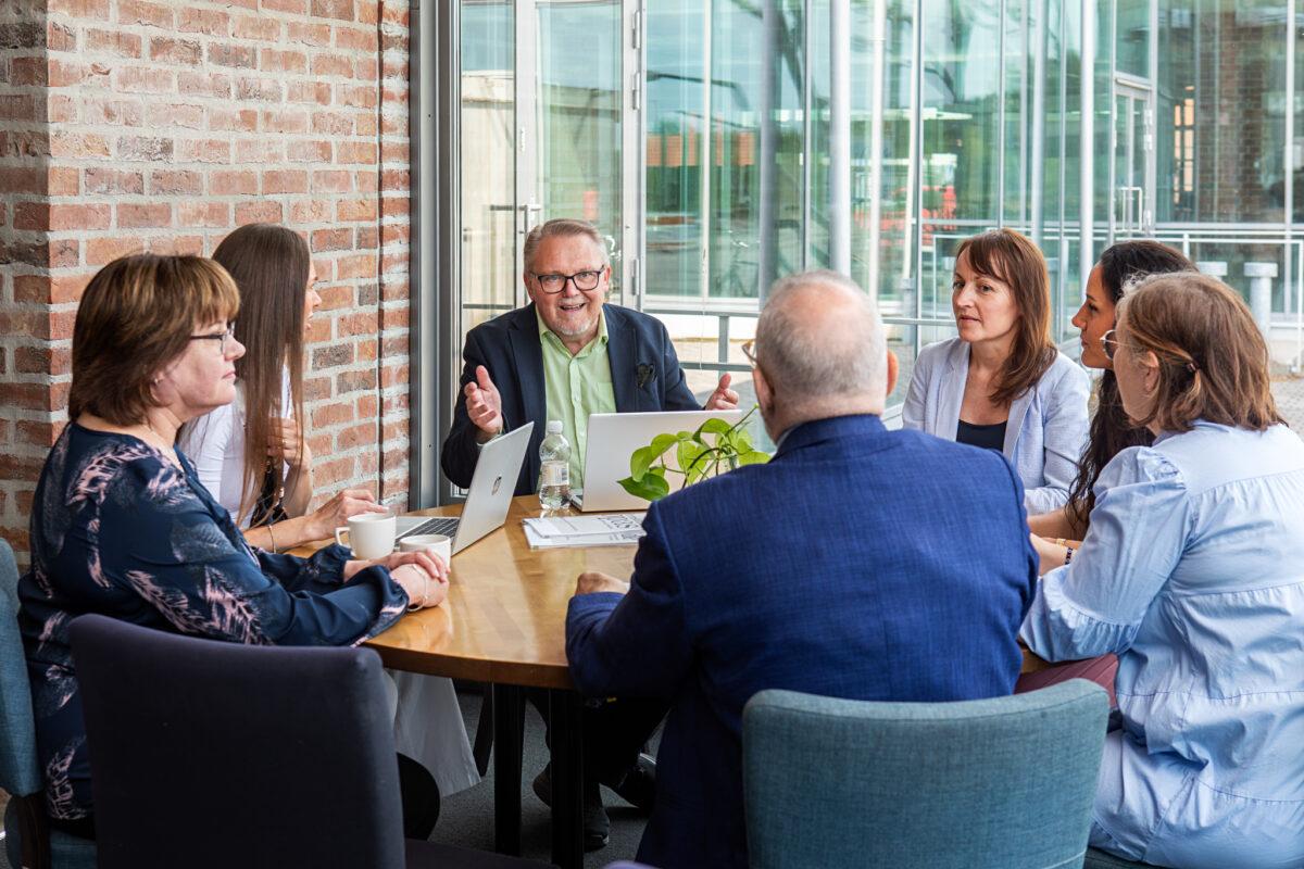 Posintralaiset pöydän ääressä keskustelemassa ja verkostoitumassa